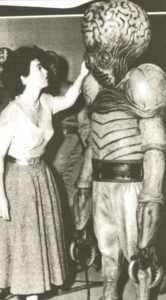 Faith Domergue checks the detailing on the mutant costume worn by Regis Parton. Faith Domergue with metaluna mutant.
